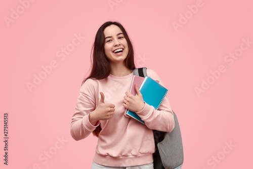 Cheerful student gesturing thumb up