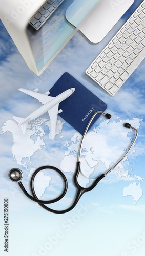 international medical travel insurance concept,stethoscope, passport, computer and airplane on sky background with global map