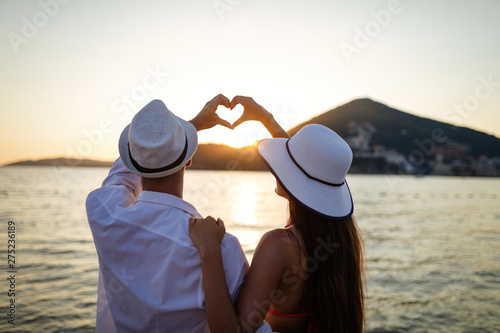 Happy couple in love walking on beach on honeymoon vacation