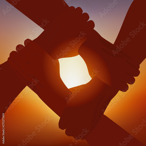 Concept de la solidarité et de l’amitié, avec quatre bras entrelacés qui symbolisent la fraternité et le partenariat, devant un soleil couchant.