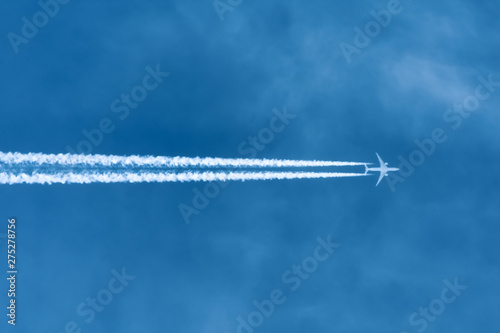 Jet aircraft flying at high altitude with contrails.