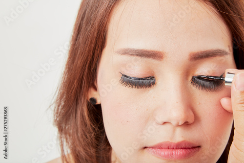 Makeup artist glues eyelashes on client