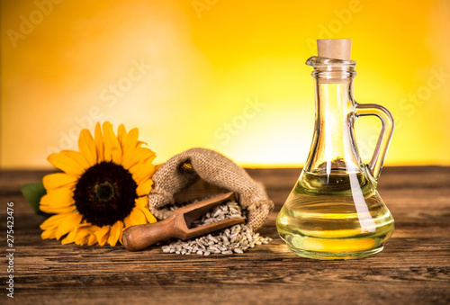 Sunflower oil in a bottle and sunflower flowers and sunflower seeds in a sack