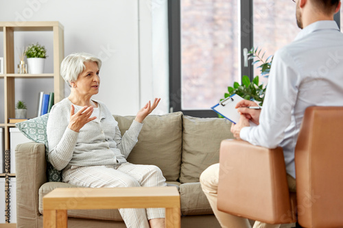 geriatric psychology, mental therapy and old age concept - senior woman patient and psychologist at psychotherapy session