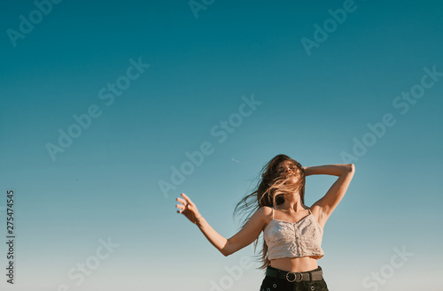 a young woman in a summer day with a blue sky - negative space