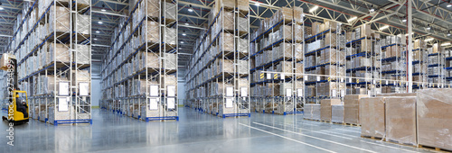 Huge distribution warehouse with high shelves and forklift