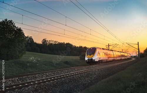 Modern German train traveling at sunset