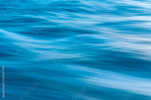 Gentle soothing silky flowing natural ocean water movement. Abstract background motion blur. Serene and peaceful deep blue sea in nature.