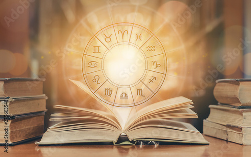 Zodiac sign horoscope astrology and constellation study for foretell and fortune telling education course concept with horoscopic wheel over old book in school library