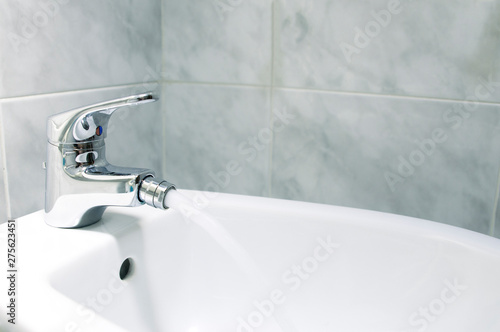 Detail of the faucet of a bidet with running water