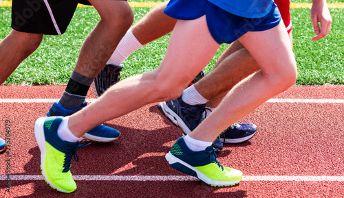 Legs of a group of runners on the track ready to start a run