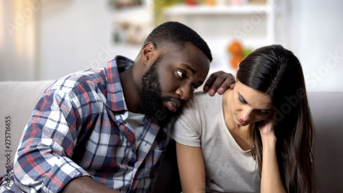 Black husband calming and supporting sad wife, health problems, miscarriage