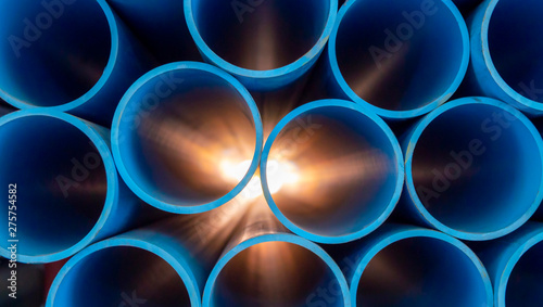 Group of blue water pipes That is stacked into a graphic format With light coming from behind