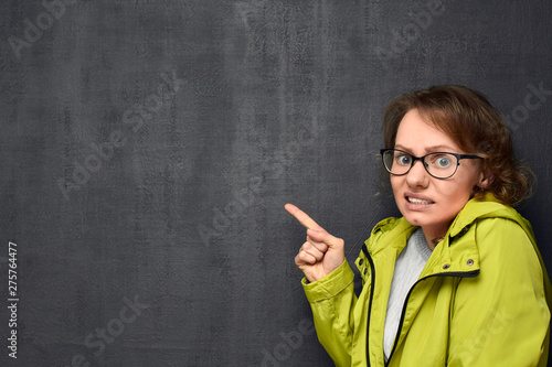 Portrait of woman pointing at something terrible