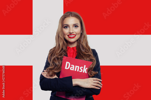 Happy young woman student with book against the Denmark flag background, travel and learn danish language concept