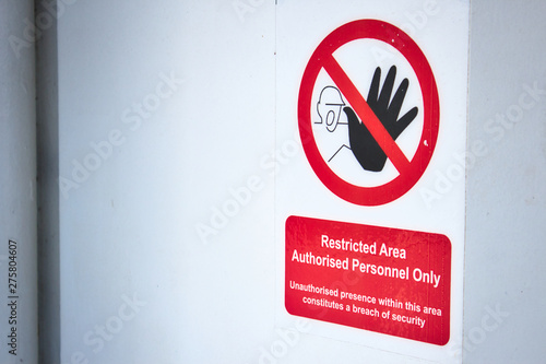 Restricted area sign on a white wall background