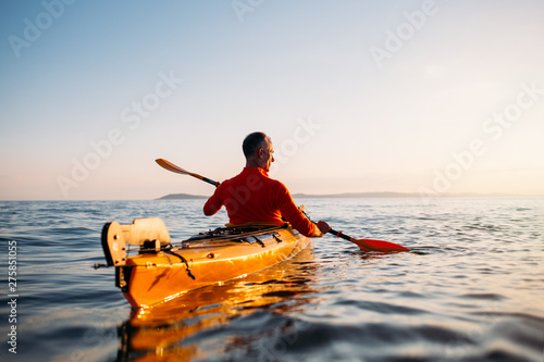 Rear view of senior man enjoy paddling kayak 