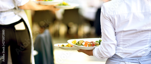 Bedienung serviert Essen für die Gäste im Restaurant