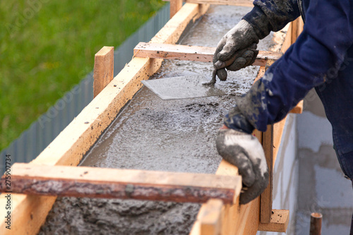 Worker levels concrete in formwork using a trowel