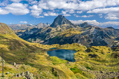 View at Ossau valley from the mountain pass Ayous in Franch Atlantic Pyrenees, as seen in October. Lake Gentau is at foreground of the famous Pyrenean peak Midi Ossau.