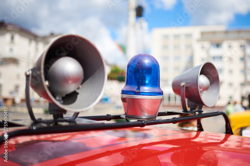 Flashing lights and sirens on the roof of an old police car