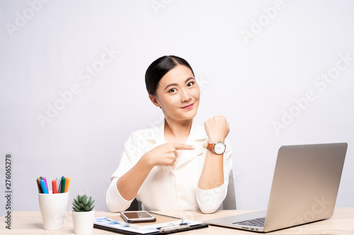 Happy woman holding hand with wrist watch at office isolated over background