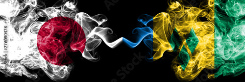 Japan vs Saint Vincent and the Grenadines smoky mystic flags placed side by side. Thick colored silky smokes combination of Saint Vincent and the Grenadines and Japanese flag