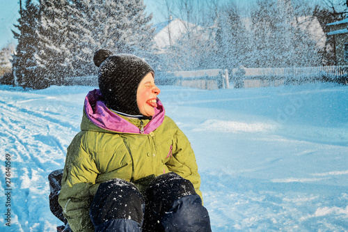 A child with the disease cerebral palsy walking in the winter. Closeup portrait. Happy and joyful boy smiling