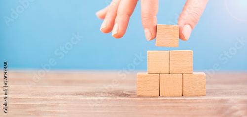 woman is placing blank blocks in a row on the blue background