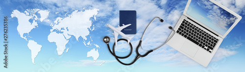 international medical travel insurance concept, stethoscope, passport, laptop computer and airplane on sky background banner with global map