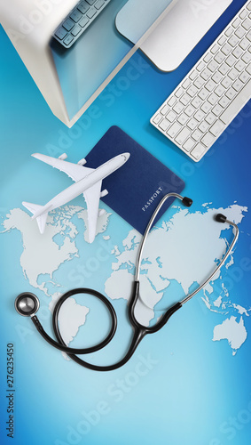 international medical travel insurance concept,stethoscope, passport, computer and airplane on sky background with global map