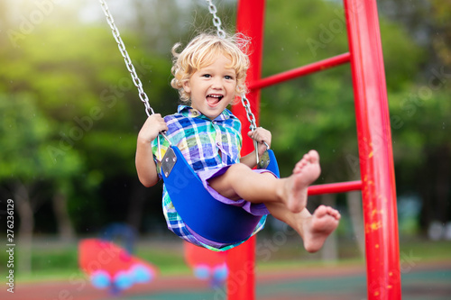 Child on playground. swing Kids play outdoor.