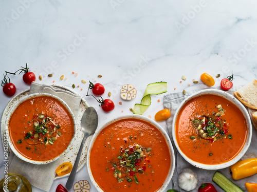 Gaspacho soup on white marble tabletop. Three bowls of traditional spanish cold soup puree gaspacho or gazpacho on light gray marble background. Copy space for text or design. Top view or flat lay.