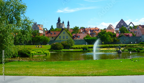 Idyllischer Stadtpark Almedalen mit See und Wasserfontäne an Sommertag in Visby, Gotland