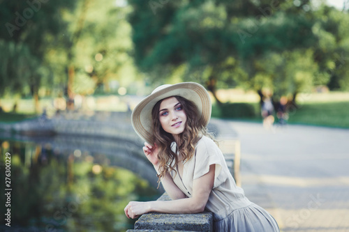 Outdoors portrait of beautiful young girl laughing in hat