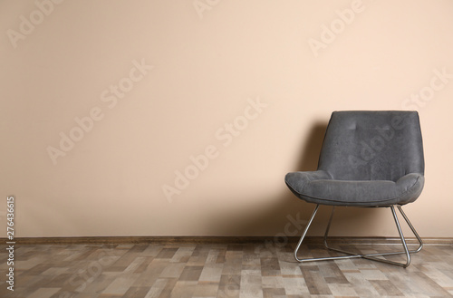 Stylish chair near color wall, space for text. Interior design