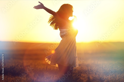 Young woman on field under sunset light