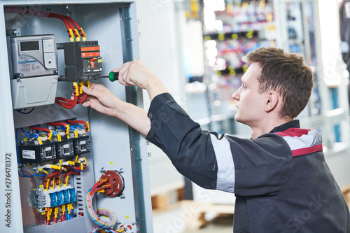 Electrician works with pliers in switchbox. current breaker installation