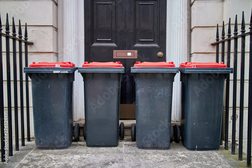 Four wheelie bins stood outside a front door.
