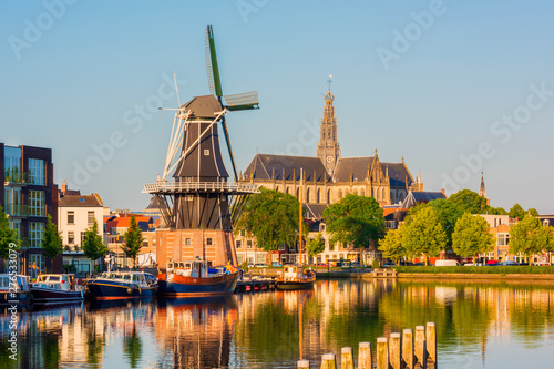 Skyline of Haarlem, North Holland, Netherlands, with Windmill "De Adriaan" from 1779 and 13th Century Saint Bavo Church. The Spaarne river flows through Haarlem.