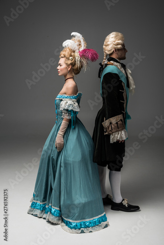 aristocratic woman and man in Victorian clothes standing back to back