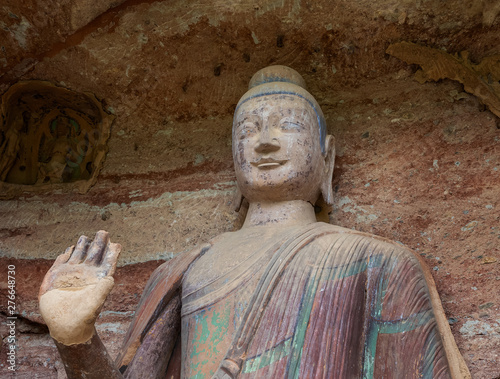Color sculpture of Buddha with colorful fresco in a grotto at Mount Maiji or Maijishan Grottoes, Tianshui, Gansu, China. Constructed from late fourth century CE. National heritage.