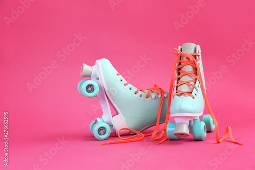 Vintage roller skates on color background