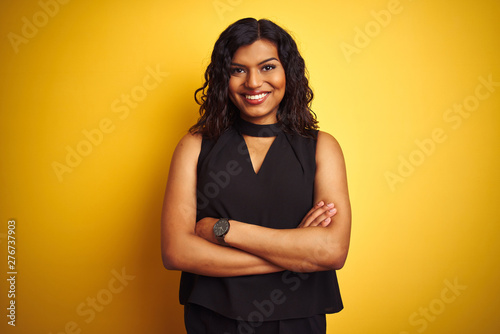 Transsexual transgender elegant businesswoman standing over isolated yellow background happy face smiling with crossed arms looking at the camera. Positive person.