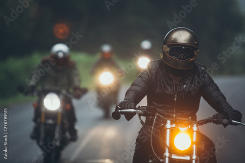 A group of motorcyclists are traveling on the rainy highway.