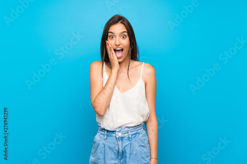 Young woman over isolated blue background with surprise and shocked facial expression