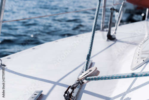 background - yachting. fragment of the hull of a sailing vessel with rigging against the backdrop of water