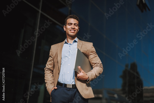 Cheerful man is going to work with notebook
