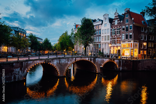 Night city view of Amsterdam canal Herengracht, typical dutch houses in evening dusk lights, Holland, Netherlands