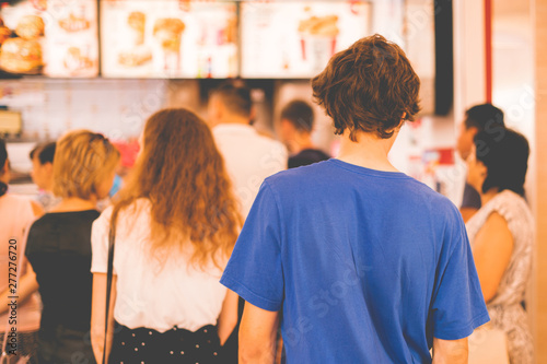 young teenager standing in a queue to receive the fastfood package